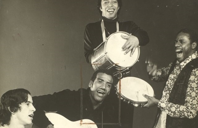 A imagem apresenta Jorge Ben e o Trio Mocotó no Teatro da Lagoa tocando tambor, pandeiro e violão